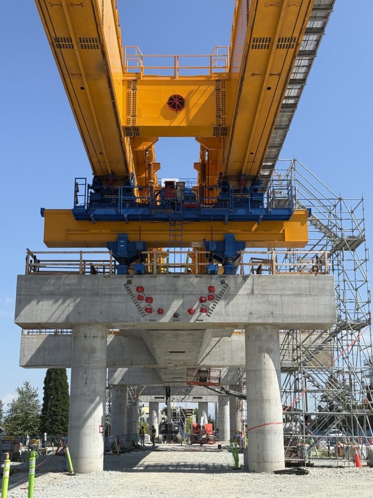 A large lifting machine called a launching gantry on top of station bents at Bakerview-166 Street Station.