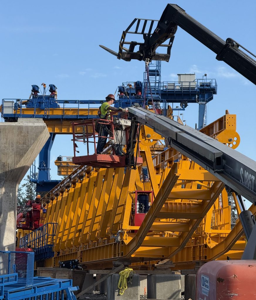 A photo of crews assembling a specialized lifting machine, known as a launching gantry.