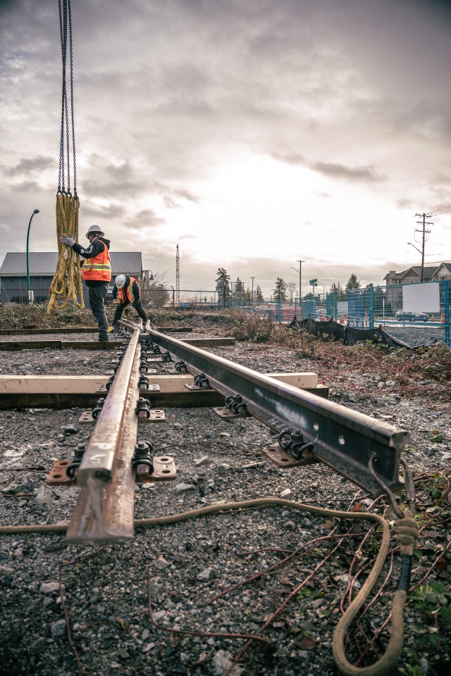 Two workers examine construction materials.
